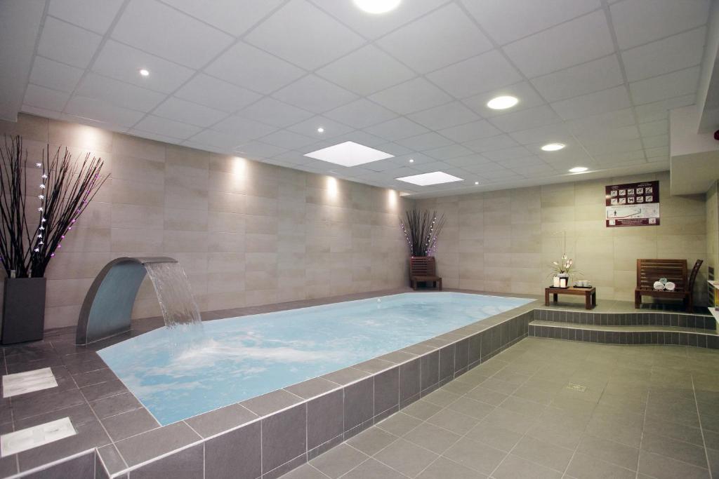 a large swimming pool with a fountain in a room at Odalys City Strasbourg Green Marsh in Strasbourg