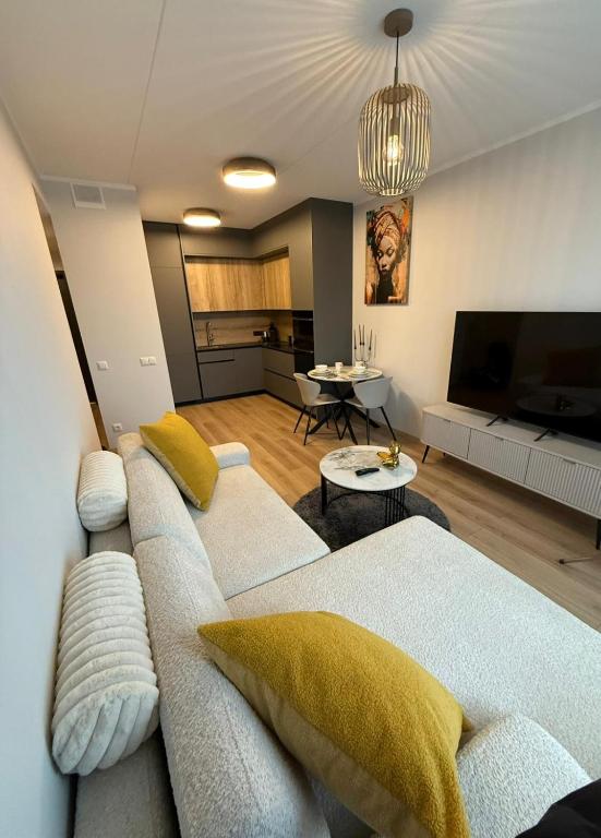 a living room with a couch and a flat screen tv at Grēdu Rezidence in Riga