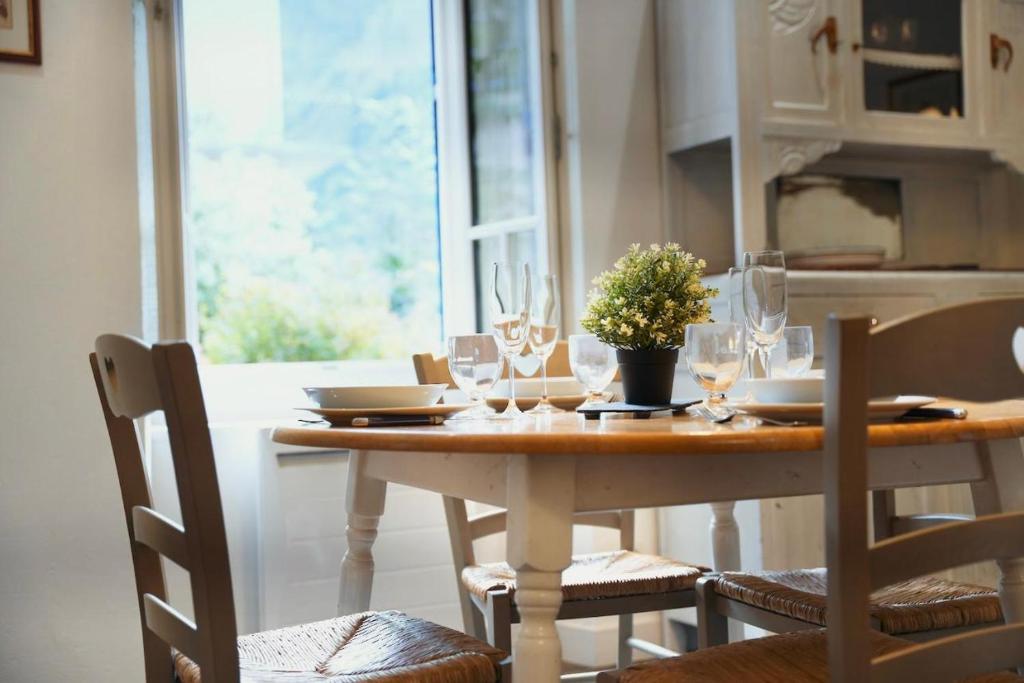 une table de salle à manger avec des verres à vin dessus dans l'établissement Charmant T2 avec jardin, 4 pers, coeur de village, à Cauterets