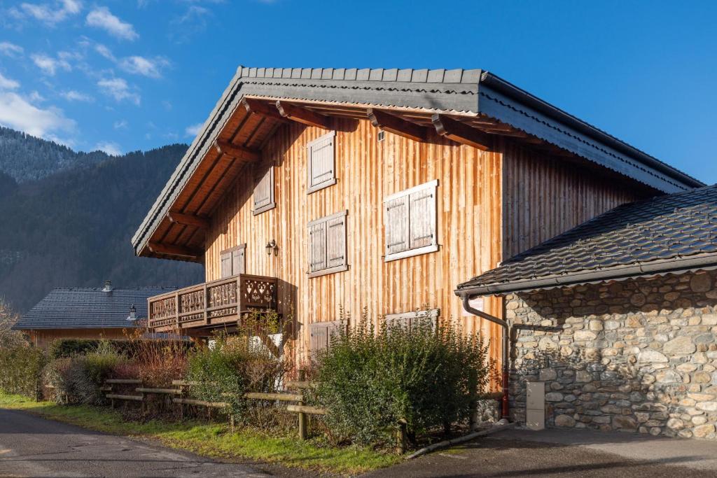 - un bâtiment en bois avec un balcon sur le côté dans l'établissement Le Lou Clerouzy - 6 personnes, à Samoëns