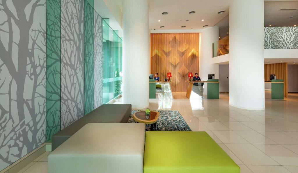 A bright lobby seating area combines colorful benches, patterned walls, and a reception counter.