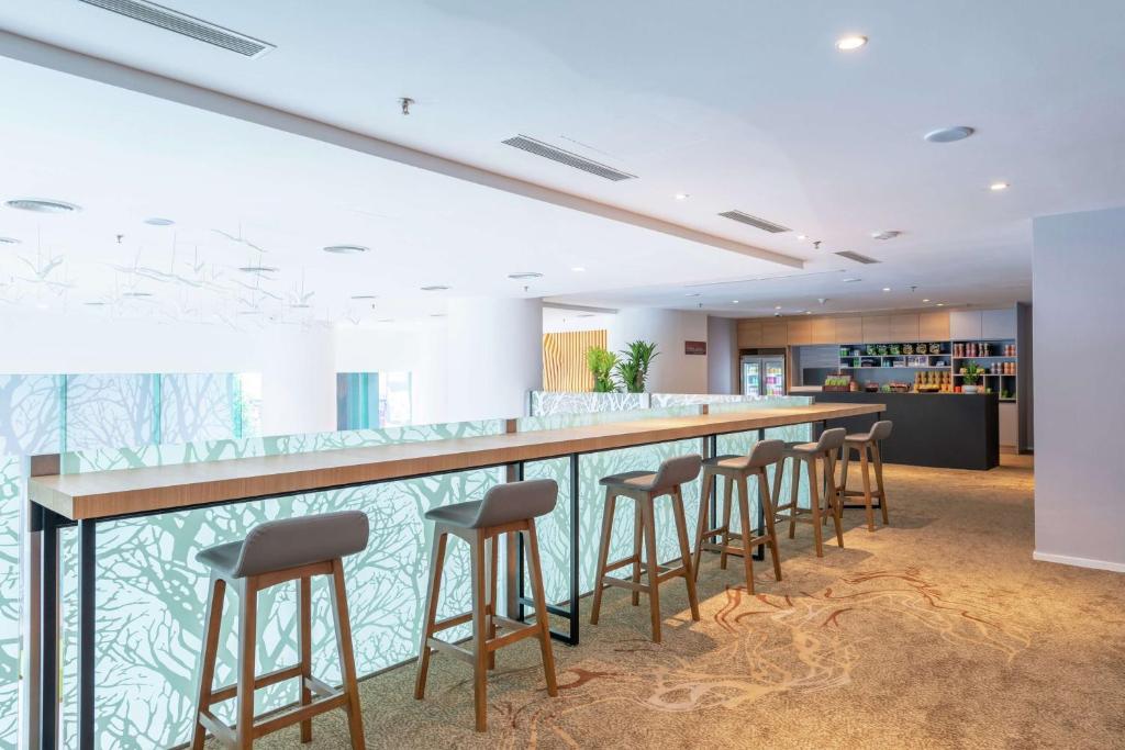 A bright lobby bar with a long counter and high stools.