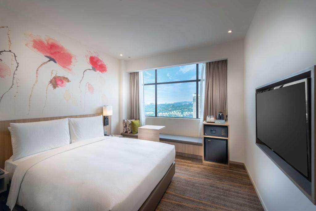 A single-bed room with a window seat, hillside view, and compact refreshment station.