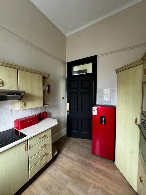 una cucina con un frigorifero rosso e una porta nera di Dior-X Manor a Durban