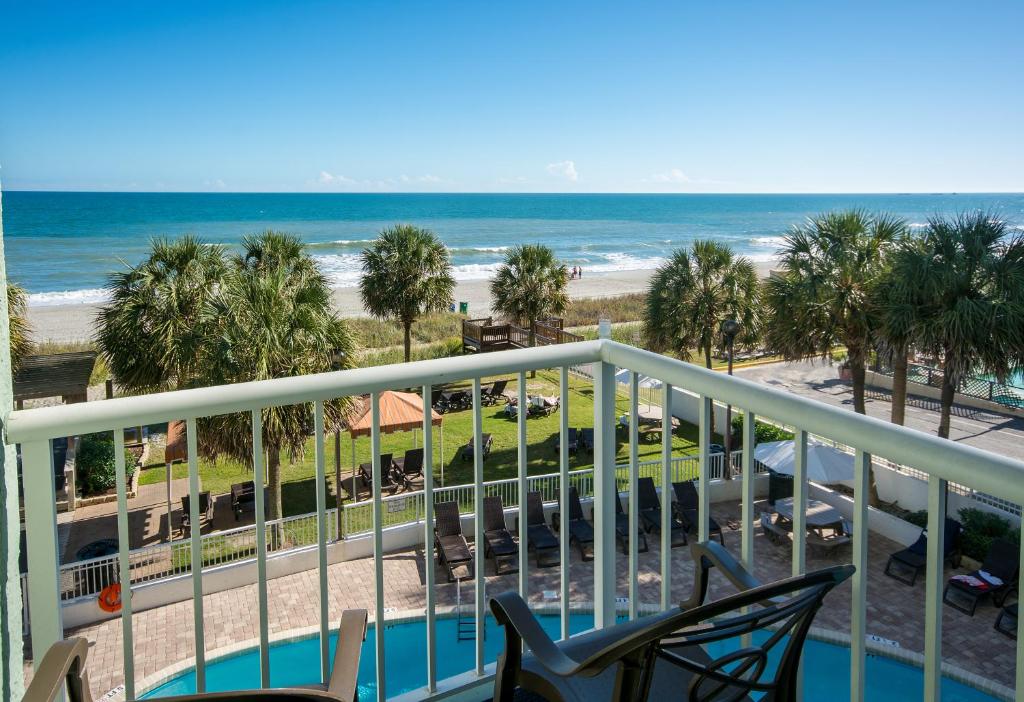 a view of the beach from the balcony of a resort at The Strand - A Boutique Resort in Myrtle Beach