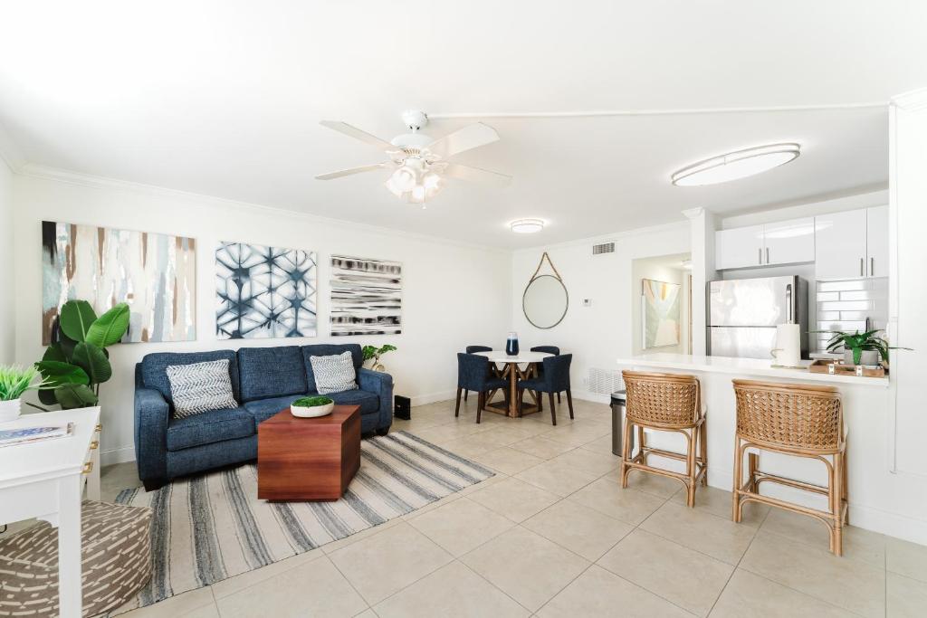 a living room with a blue couch and a kitchen at Elegant Escape! in Boca Raton