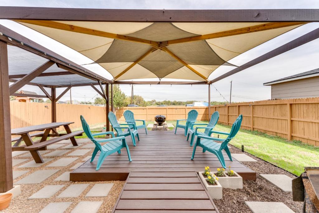 a patio with blue chairs and a wooden deck at Near Hiking Trails Home with Deck in San Antonio! in San Antonio