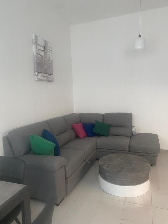 a living room with a gray couch with colorful pillows at Casa ELLI in Rimini