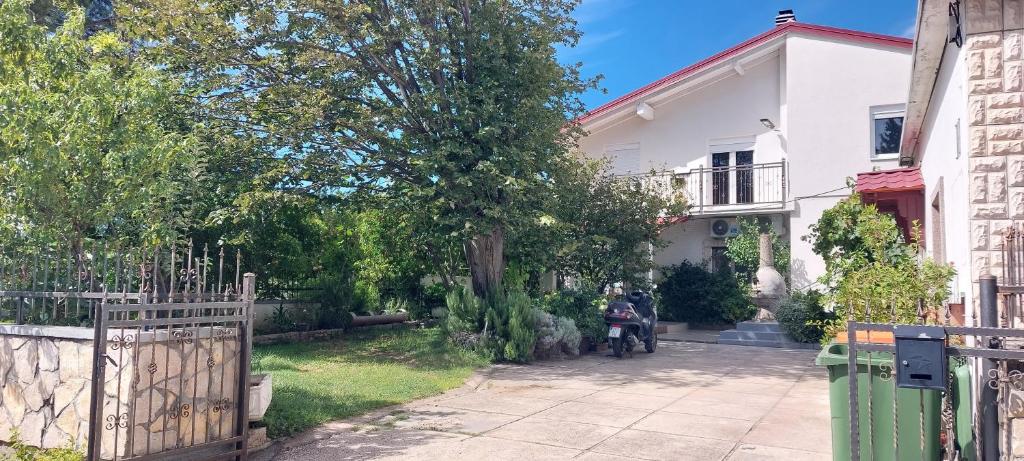 a motorcycle parked in front of a white house at Apartmani Tinka in Starigrad