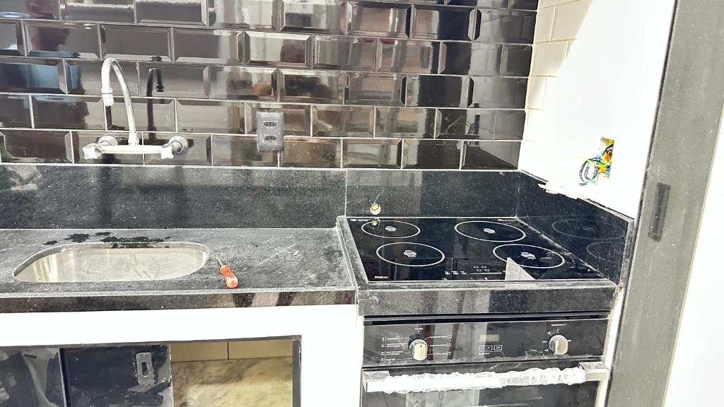 里约热内卢Avenida NOSSA SENHORA DE COPACABANA 363 TRES QUARTOS 5 CAMAS A 200 METROS DA PRAIA DE COPACABANA的带炉灶和水槽的厨房