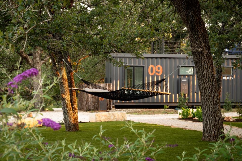 a hammock hanging between two trees in a garden at ParcBlu in Fredericksburg