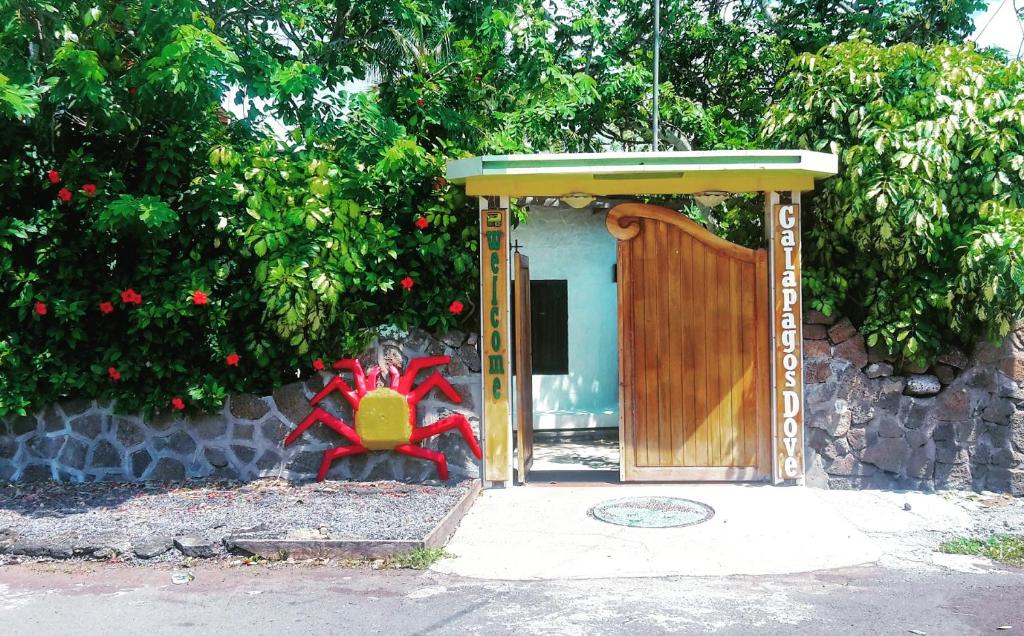 Eine Tür zu einem Haus mit einer roten Kreatur davor. in der Unterkunft Galapagos Dove in Puerto Ayora