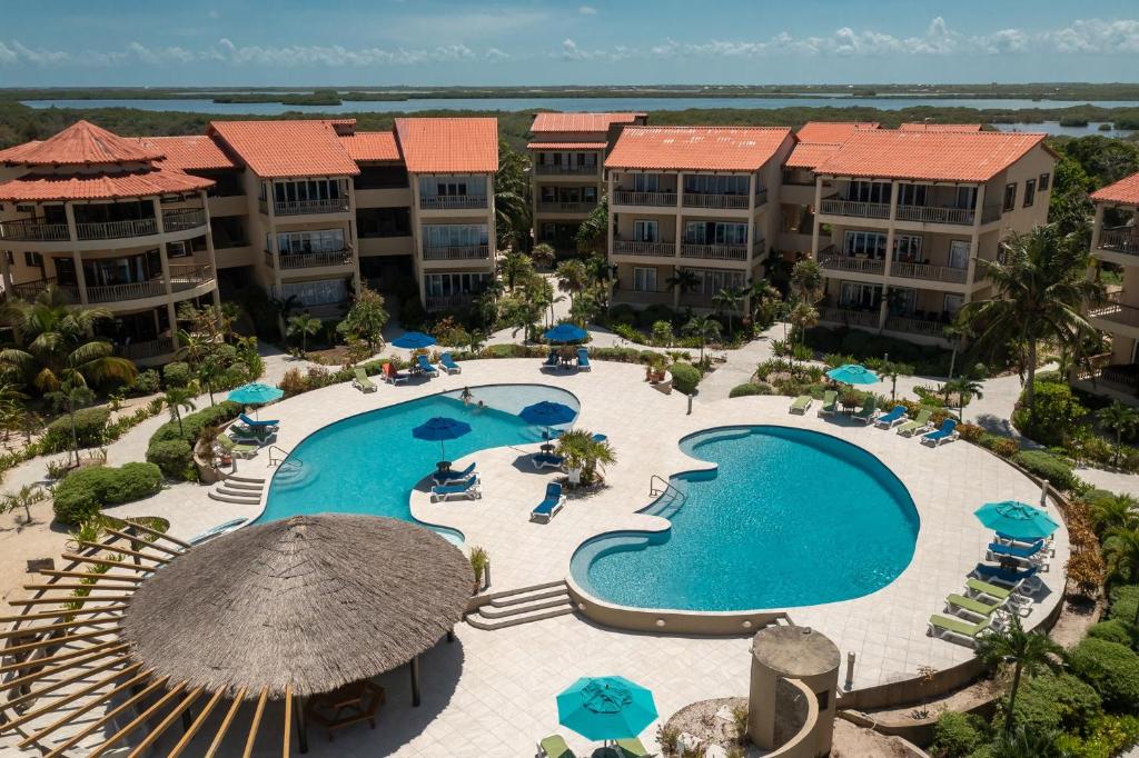 an aerial view of a resort pool with chairs and umbrellas at Residences at Barrier Reef 3B Oceanview 2 BR by Stay Floreo in San Pedro