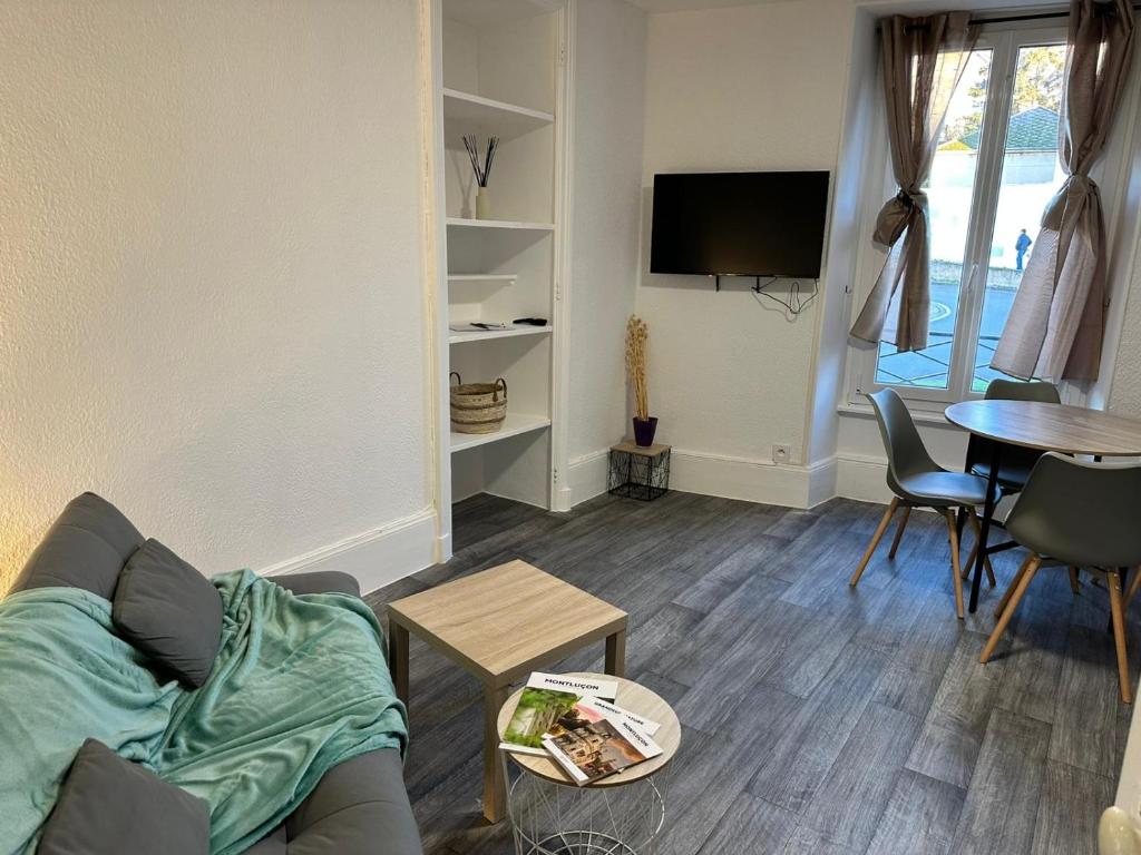 un salon avec un canapé et une table dans l'établissement Le MONTLUSPOT, à Montluçon