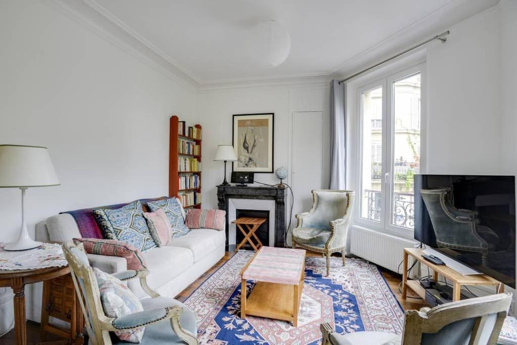 un salon avec un canapé et une cheminée dans l'établissement Bel appartement parisien - Les Gobelins, à Paris