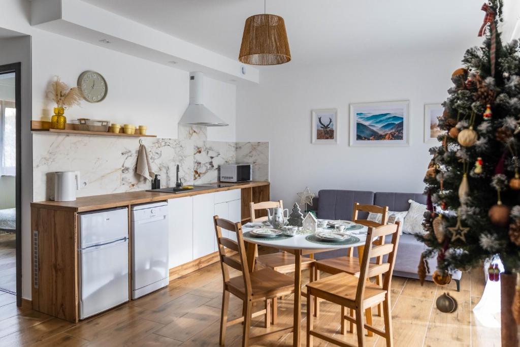 a kitchen and dining room with a christmas tree at Apartamenty Beskidy in Tylicz