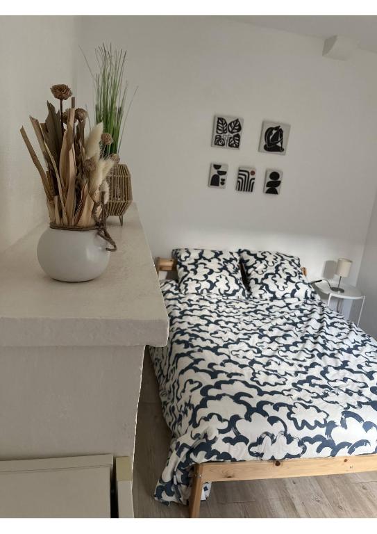 - une chambre avec un lit et un vase sur un comptoir dans l'établissement Charme et confort dans le centre-ville de Falaise, à Falaise