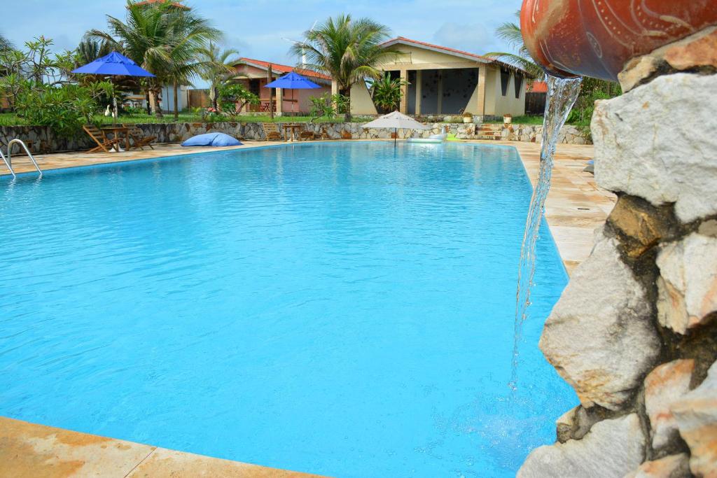 a large swimming pool with a water fountain at Pousada Oceania in Taíba