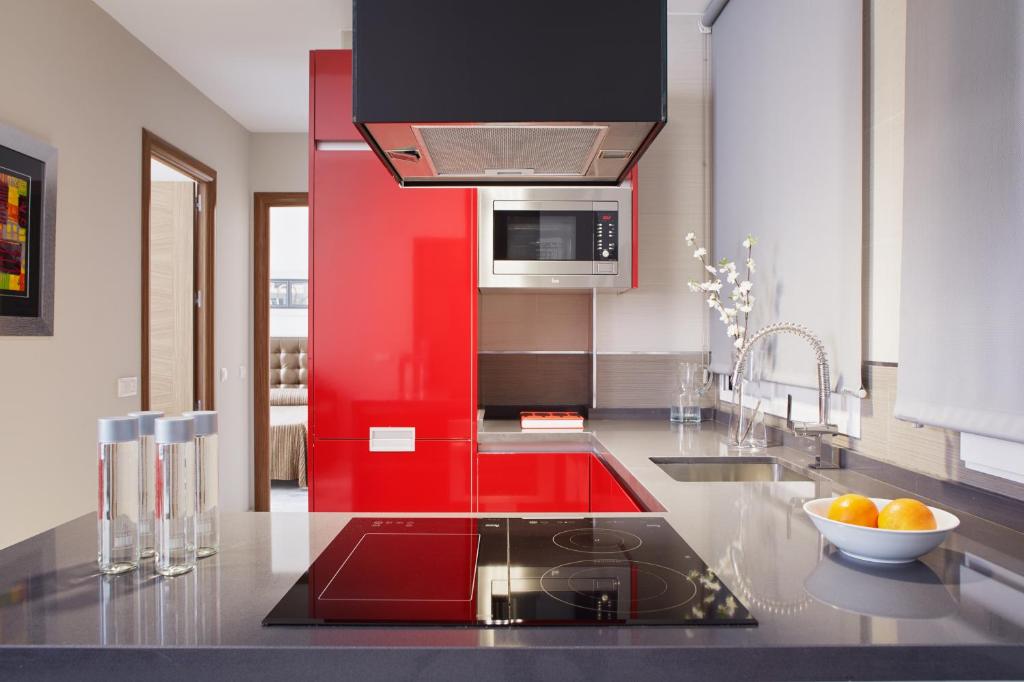 a kitchen with a sink and a red wall at Citizentral Juristas in Valencia