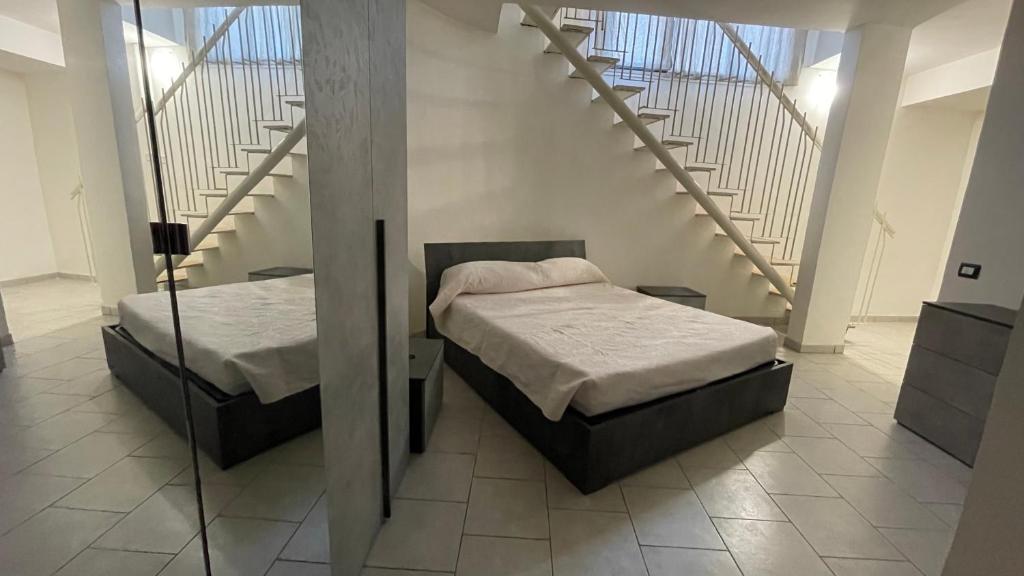 two beds in a room with a staircase at Sweet Home in Santa Marinella