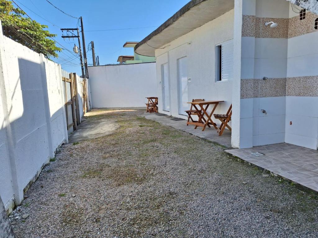 a patio with a picnic table next to a white building at Casa da Maria Ubatuba in Ubatuba