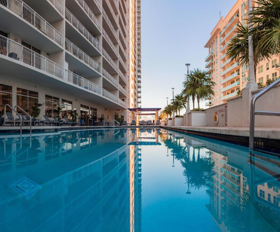a swimming pool in a hotel with palm trees and buildings at Lujoso apartamento en Brickell in Miami
