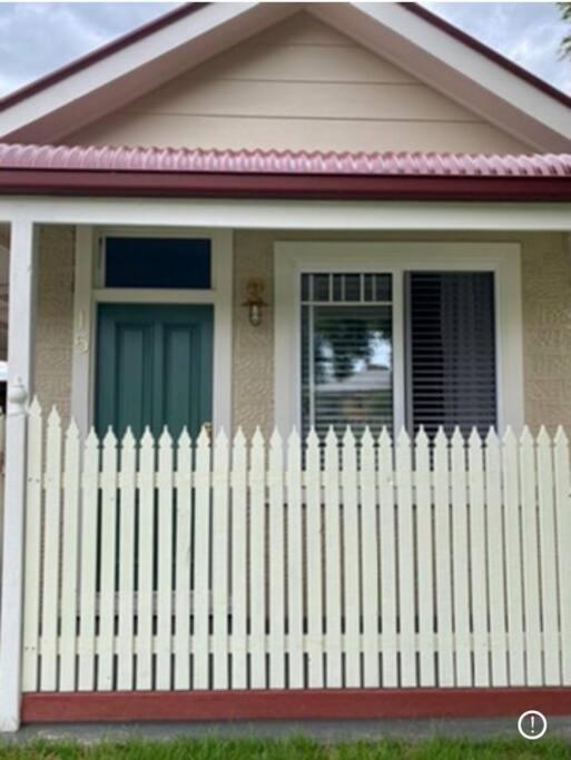a white fence in front of a small house at Bakery Cottage Moyhu in Moyhu