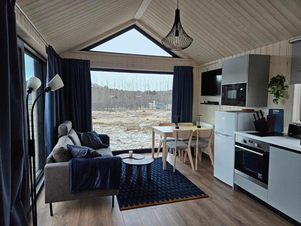 eine Küche und ein Wohnzimmer mit einer Couch und einem Tisch in der Unterkunft Úthlíd Cottages in Úthlid