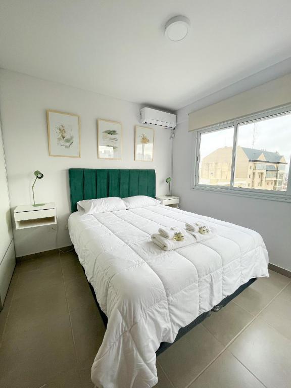 a large white bed in a bedroom with a window at Saavedra 118 8D by depptö in Bahía Blanca