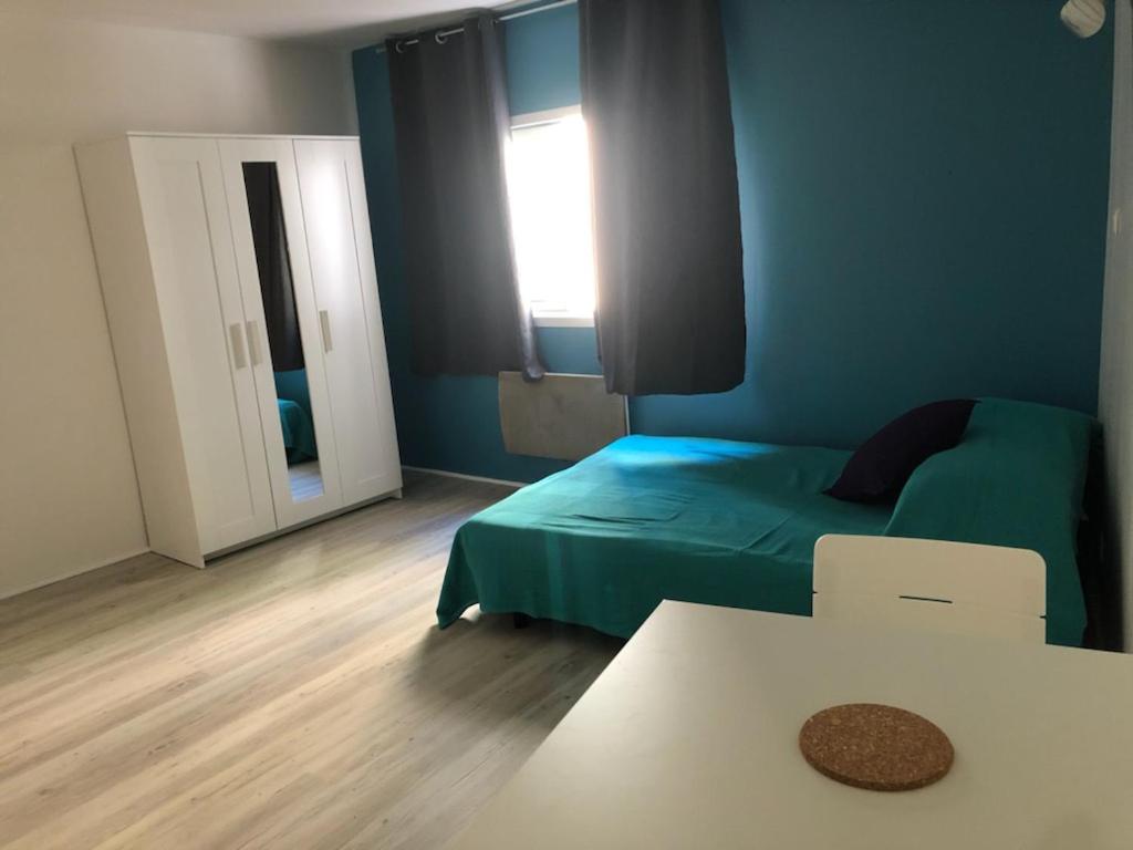une chambre avec un lit, une table et une fenêtre dans l'établissement Studio centre ville Vichy, à Vichy