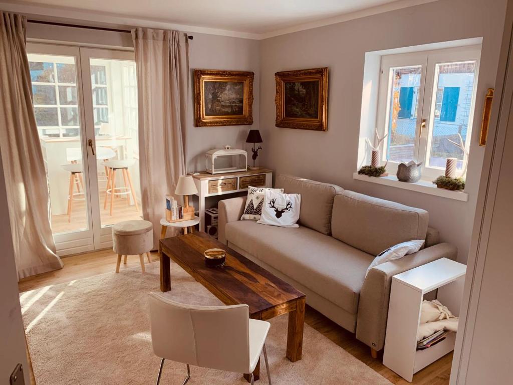 a living room with a couch and a table at Das Edelweiß Apartment by ALA Living - stilvoll Urlauben mit traumhaftem Ausblick, Sonnenterrasse, 200m zur Zugspitzbahn! in Grainau
