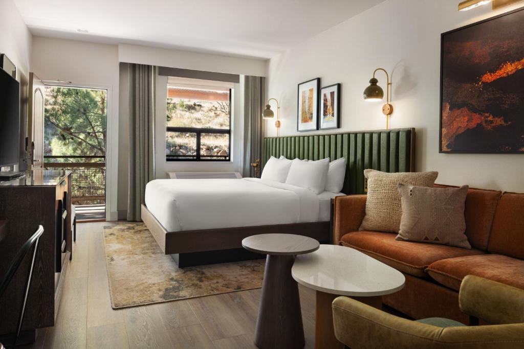 a hotel room with a bed and a couch at The Red Cliffs Lodge Zion, a Tribute Portfolio Hotel in Springdale