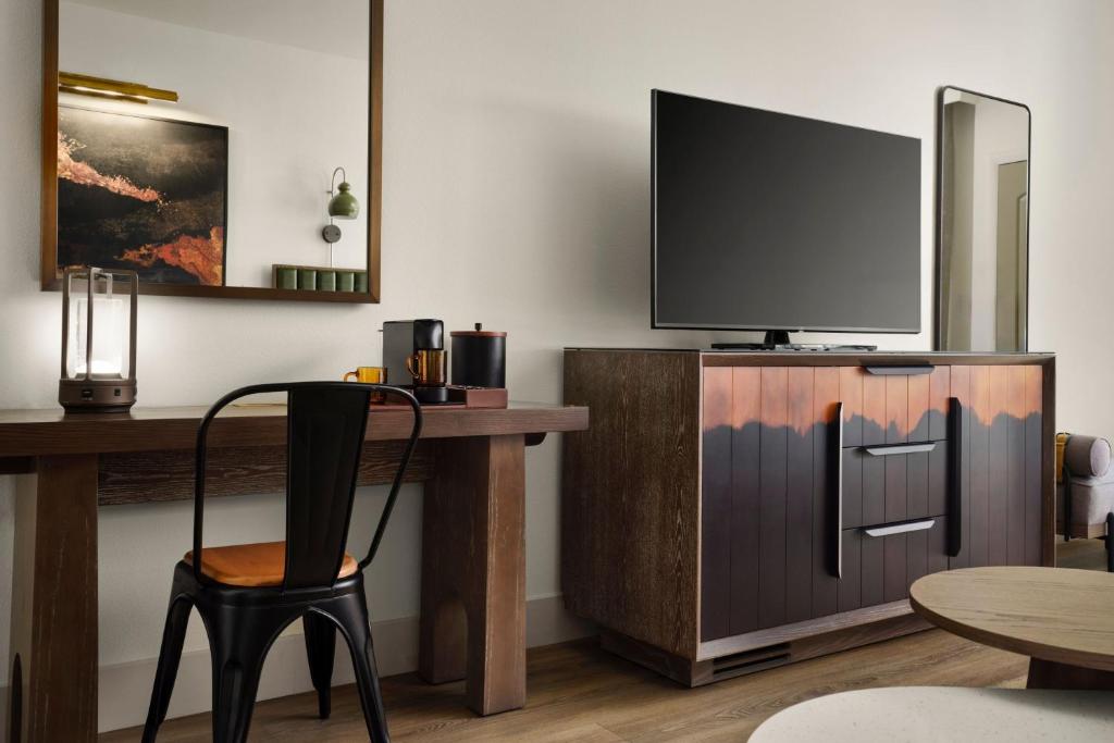 a room with a desk with a tv and a chair at The Red Cliffs Lodge Zion, a Tribute Portfolio Hotel in Springdale