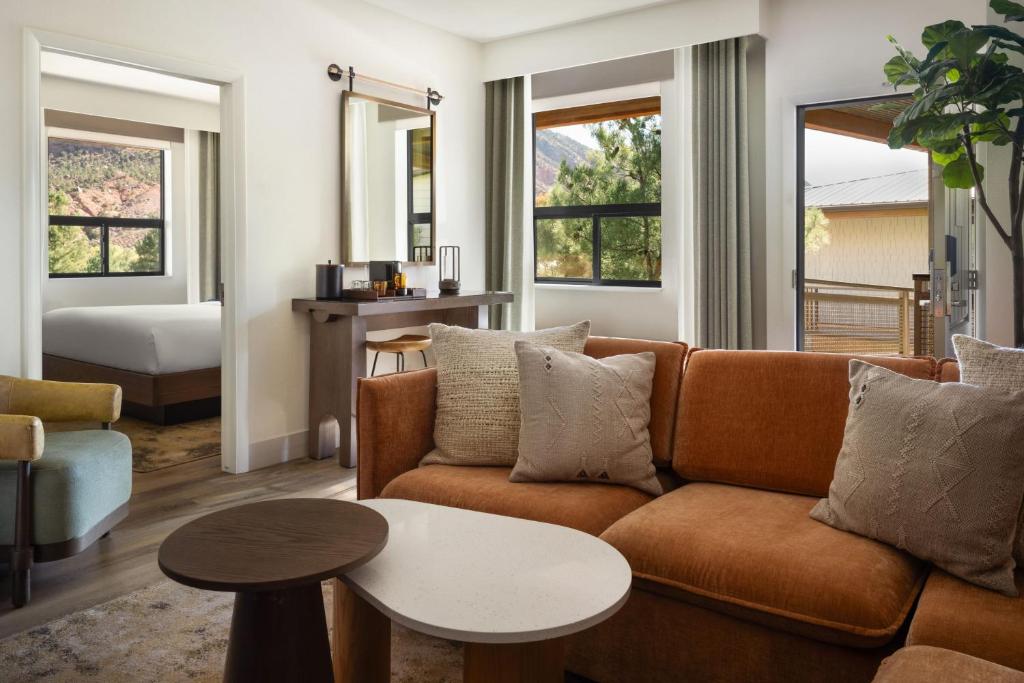 a living room with a couch and a table at The Red Cliffs Lodge Zion, a Tribute Portfolio Hotel in Springdale