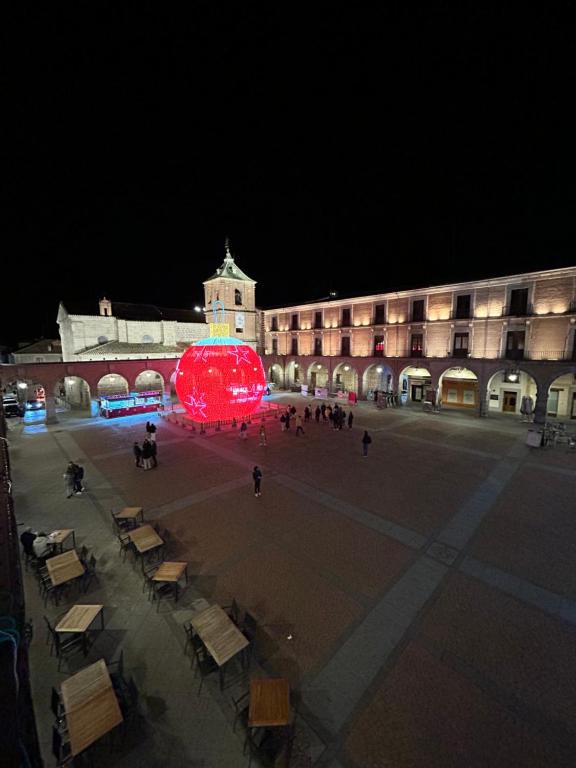 a large building with a large red object in the middle of a courtyard at Mercado Chico SUITES in Avila