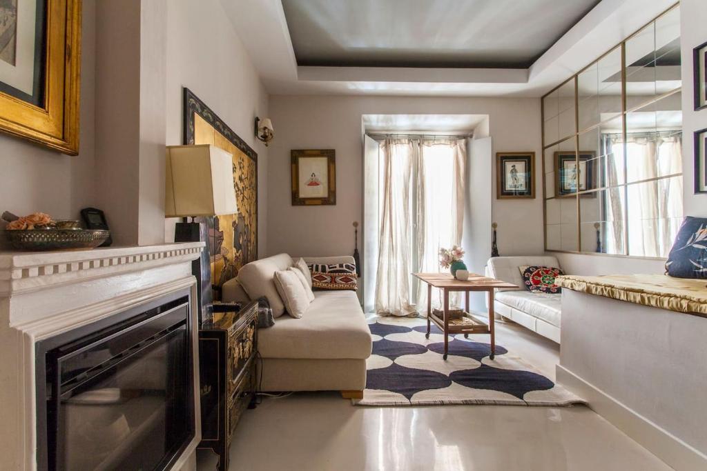 a living room with a fireplace and a couch at Duplex and terrace overlooking Giralda in Seville
