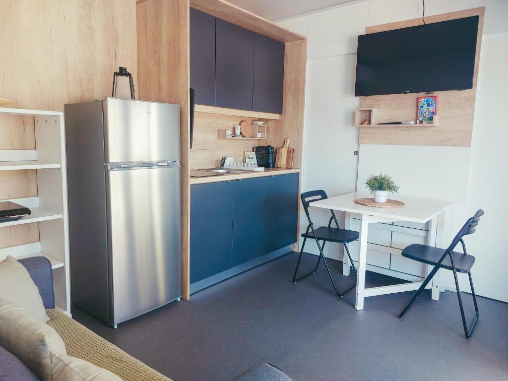 a kitchen with a refrigerator and a table with chairs at Mobile homes Laguna, beach Porat, Drage in Drage