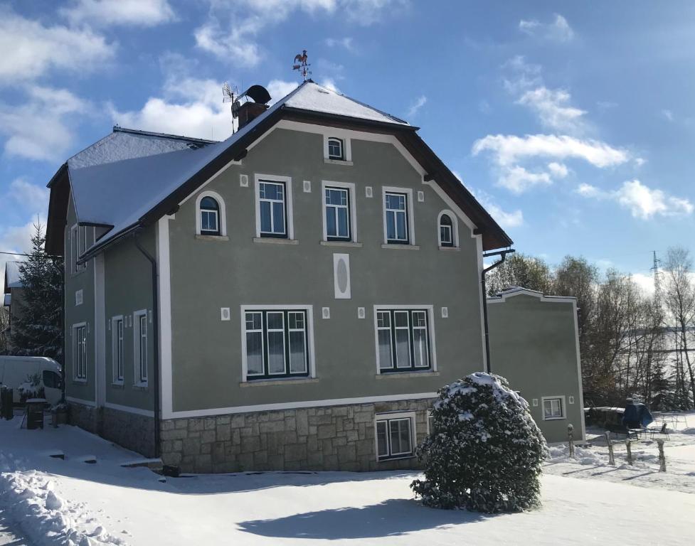 ein Haus mit einem Kreuz auf dem Dach im Schnee in der Unterkunft Penzion 1914 in Rádlo