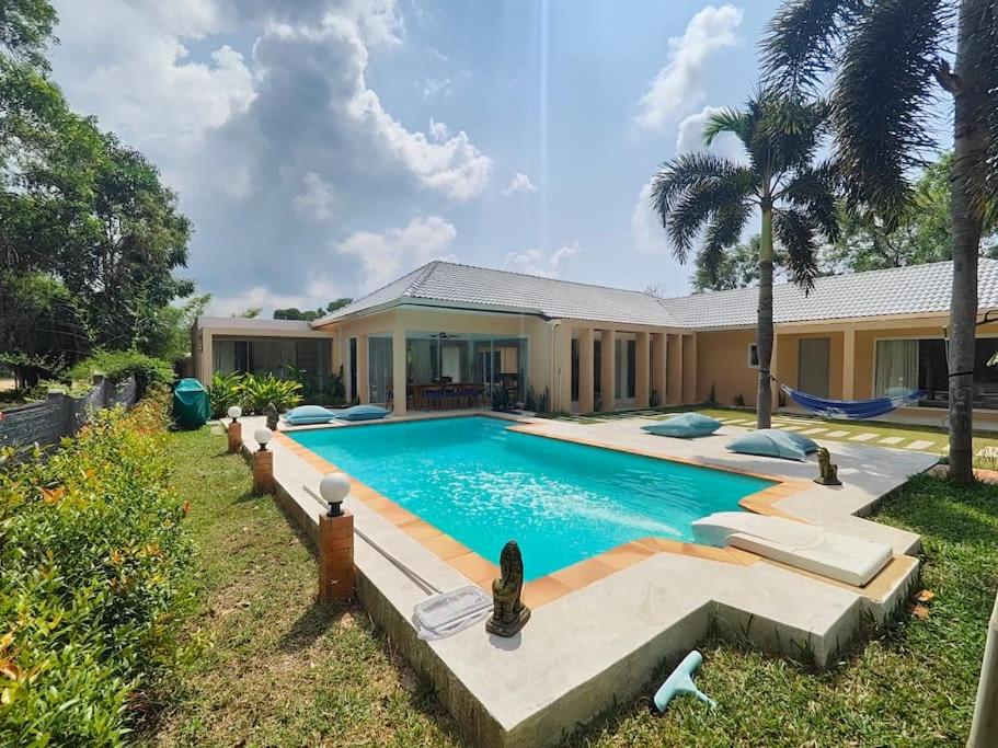 a swimming pool in front of a house at Villa Douce in Thongsala
