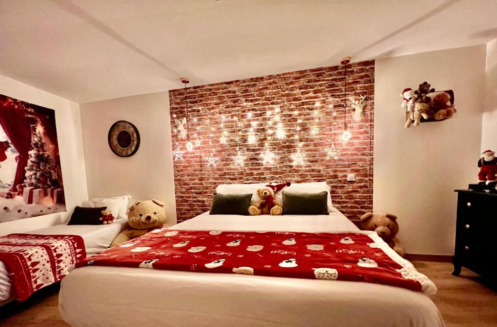 - une chambre avec deux ours en peluche assis sur un lit dans l'établissement La maison de Noel et ses lutins, à Calais