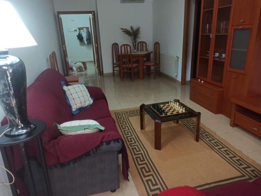 a living room with a red couch and a table at Apartamento Soler Dreams Cehegín in Cehegín