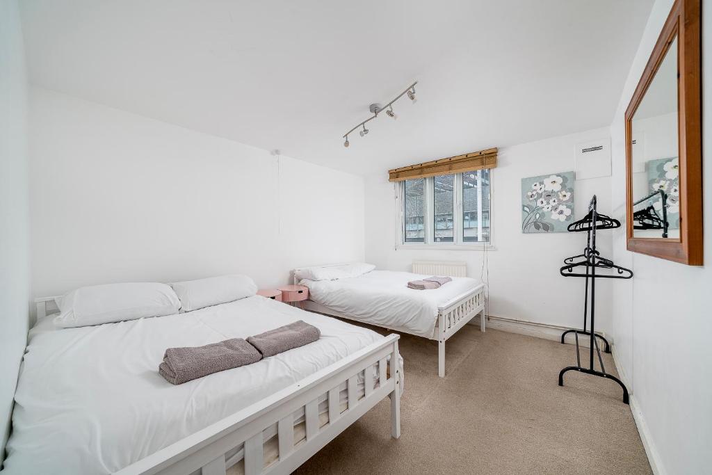 une chambre avec deux lits et une fenêtre dans l'établissement Warm & Cosy Flat in King Cross, à Londres