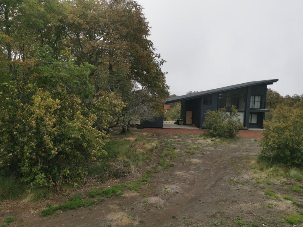 a house with a dirt road in front of it at Emai in Las Trancas