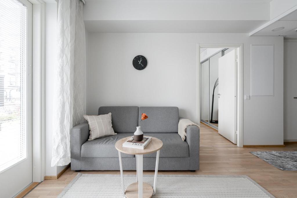 a living room with a couch and a table at Modern 1BR Apartment in Kaleva next to Tram Line in Tampere