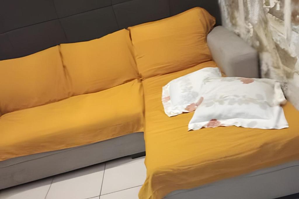 a yellow couch with a pillow on it at Apto no térreo com 2 quartos in Belo Horizonte