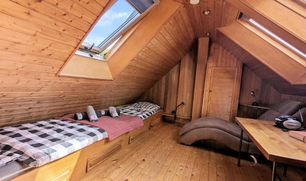 ヴィーク・アウフ・リューゲンにあるstayMA Strandhaus Wiek - Erholen Kitesurfen Wandern und Meerのベッドと窓が備わる屋根裏部屋