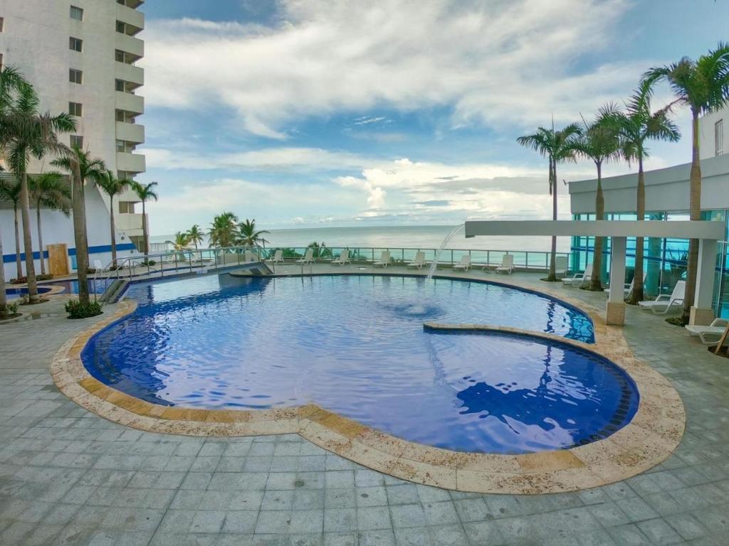 a large swimming pool with a view of the ocean at Luxury Apartments Beachview in Cartagena de Indias