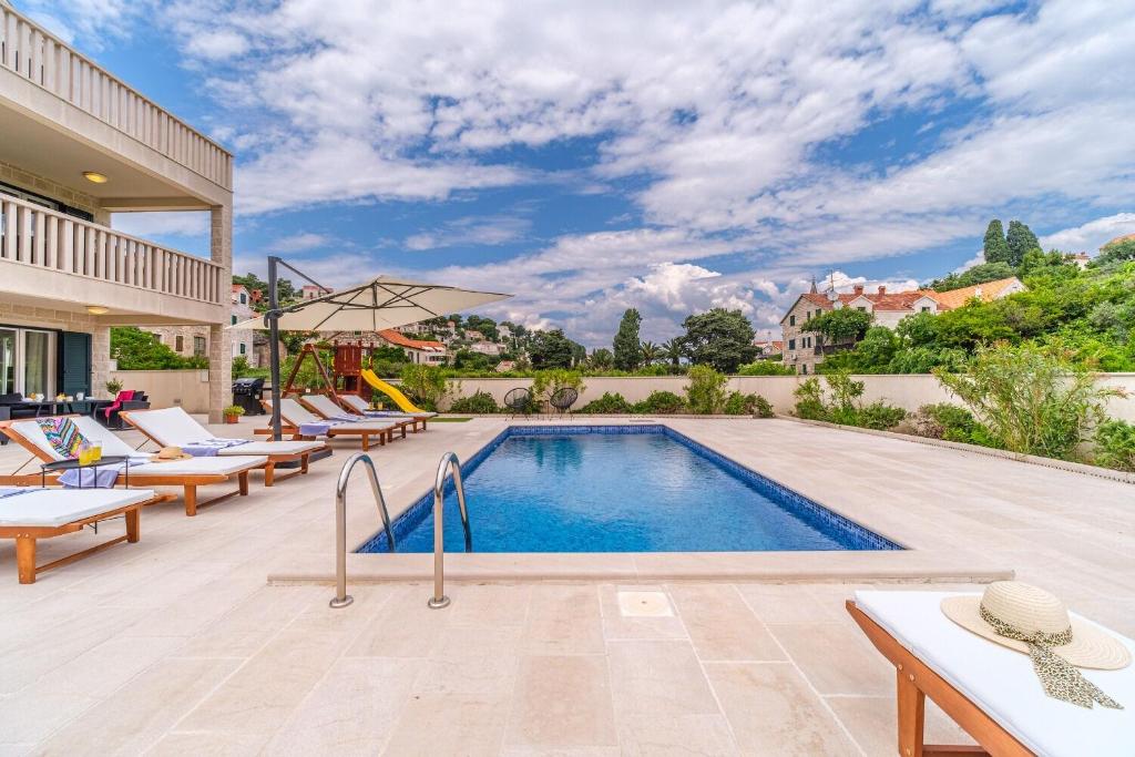 a swimming pool with lounge chairs and a resort at House Villa Gold in Splitska