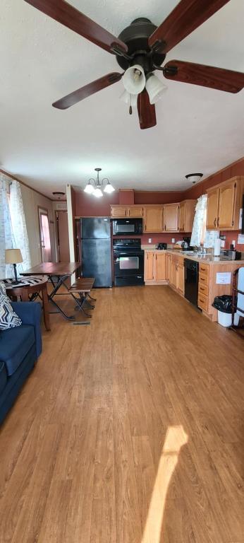 a living room with a ceiling fan and a kitchen at The Lake House in Hillsboro