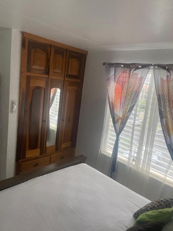 a bedroom with a bed and a window with curtains at New Kingston Gem in Kingston